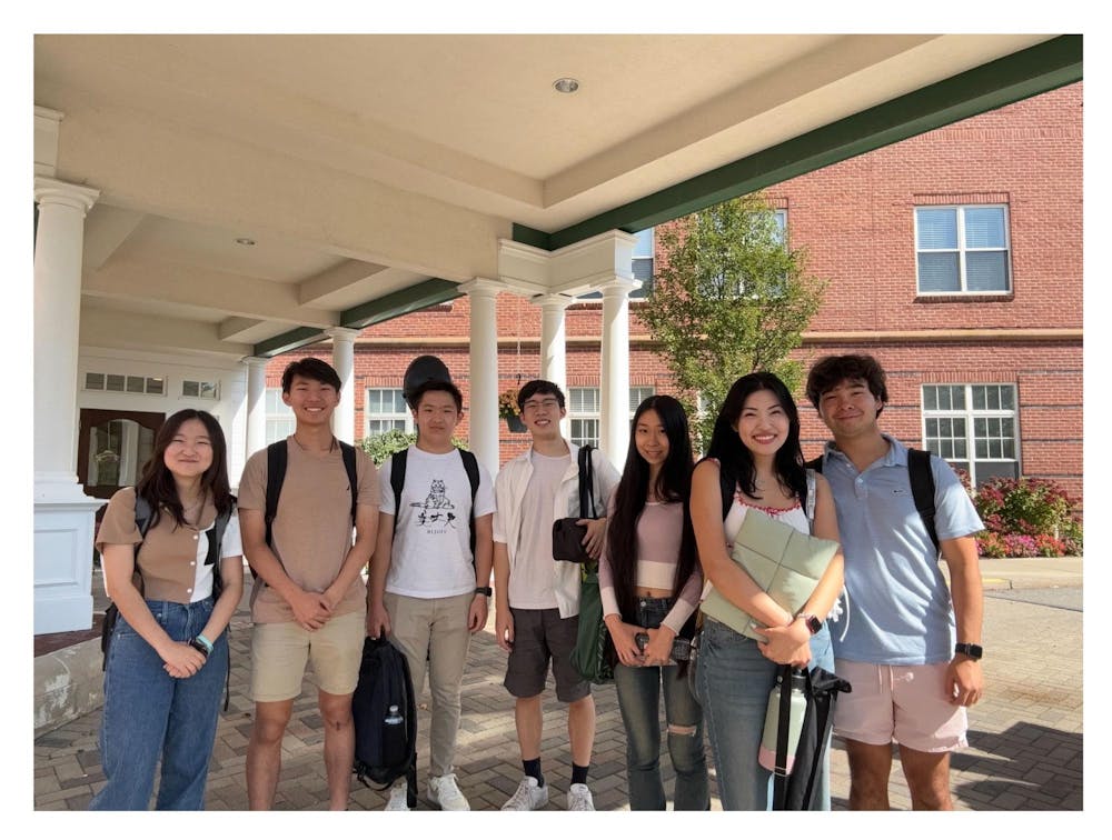 Seven club members pose side by side carrying their instruments.