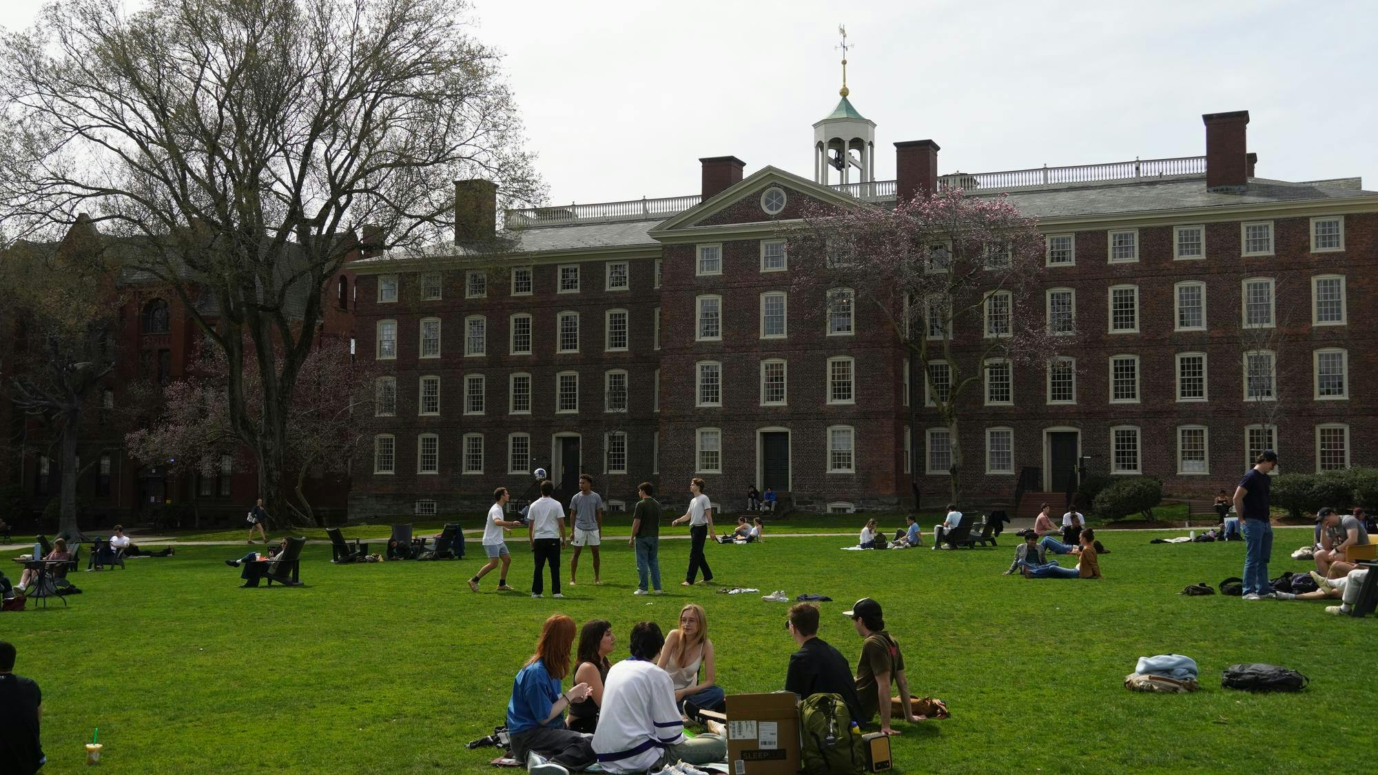Students on the Main Green on a sunny day with University Hall in the background. 