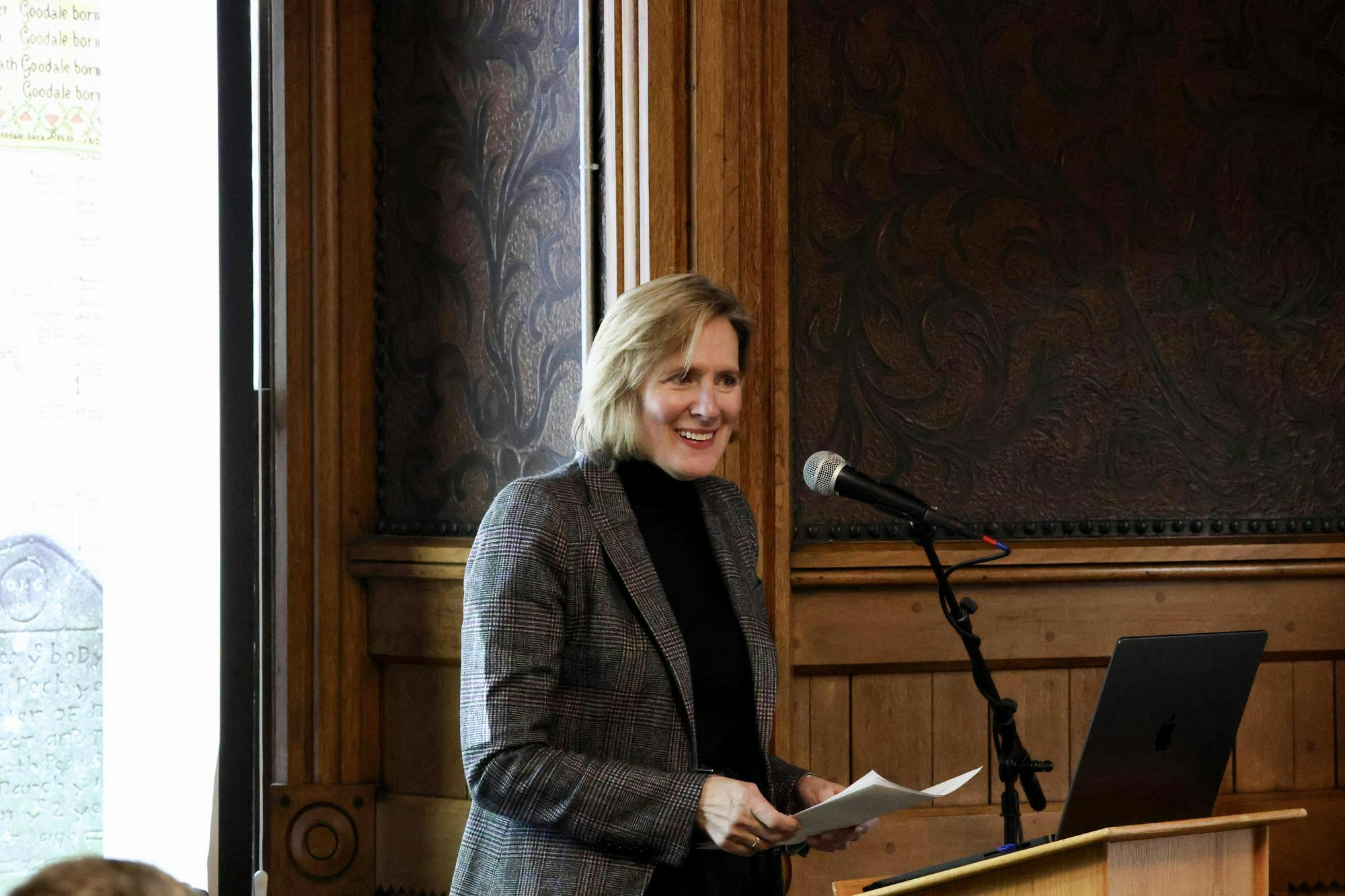 Professor Wulf standing behind a microphone and giving her talk.
