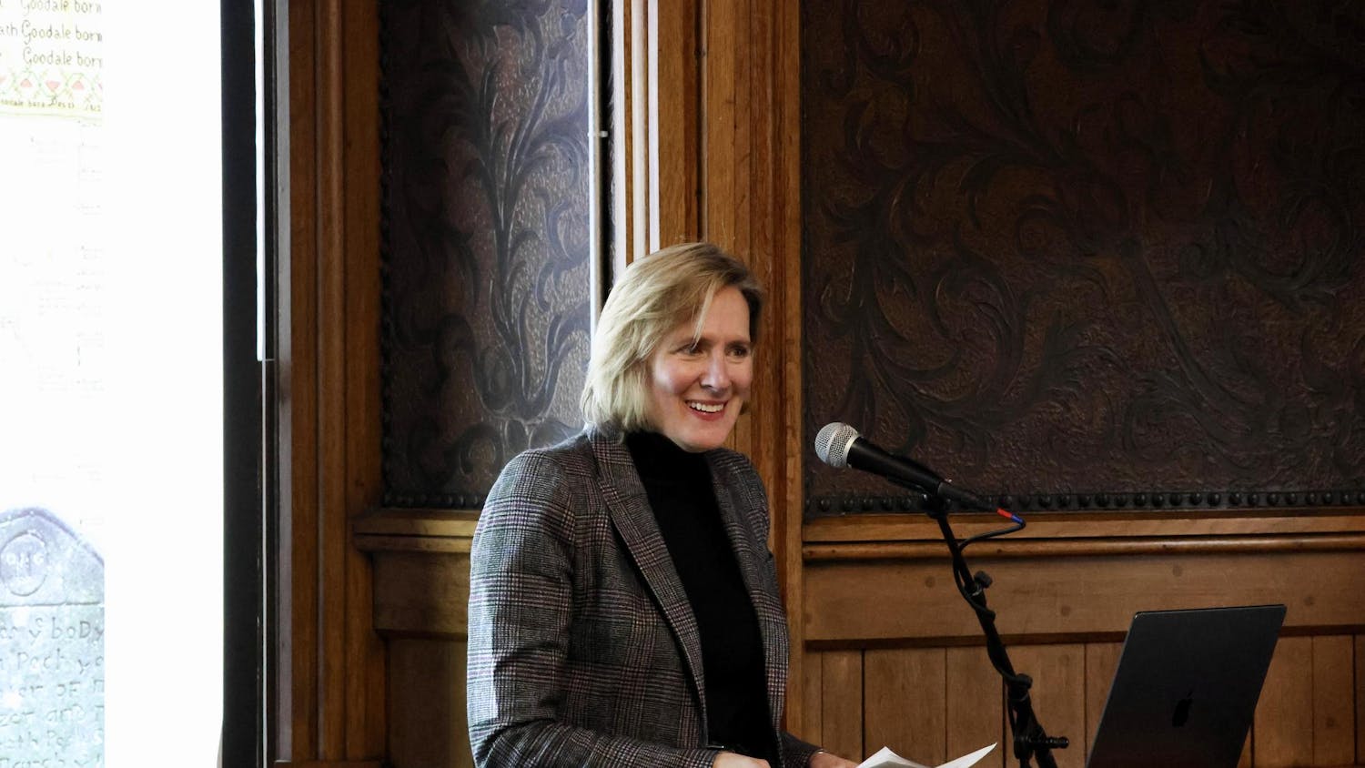 Professor Wulf standing behind a microphone and giving her talk.