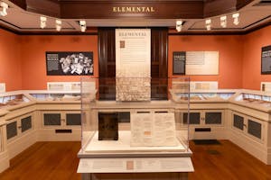 Display of old books in glass with exhibit titled "Elemental."