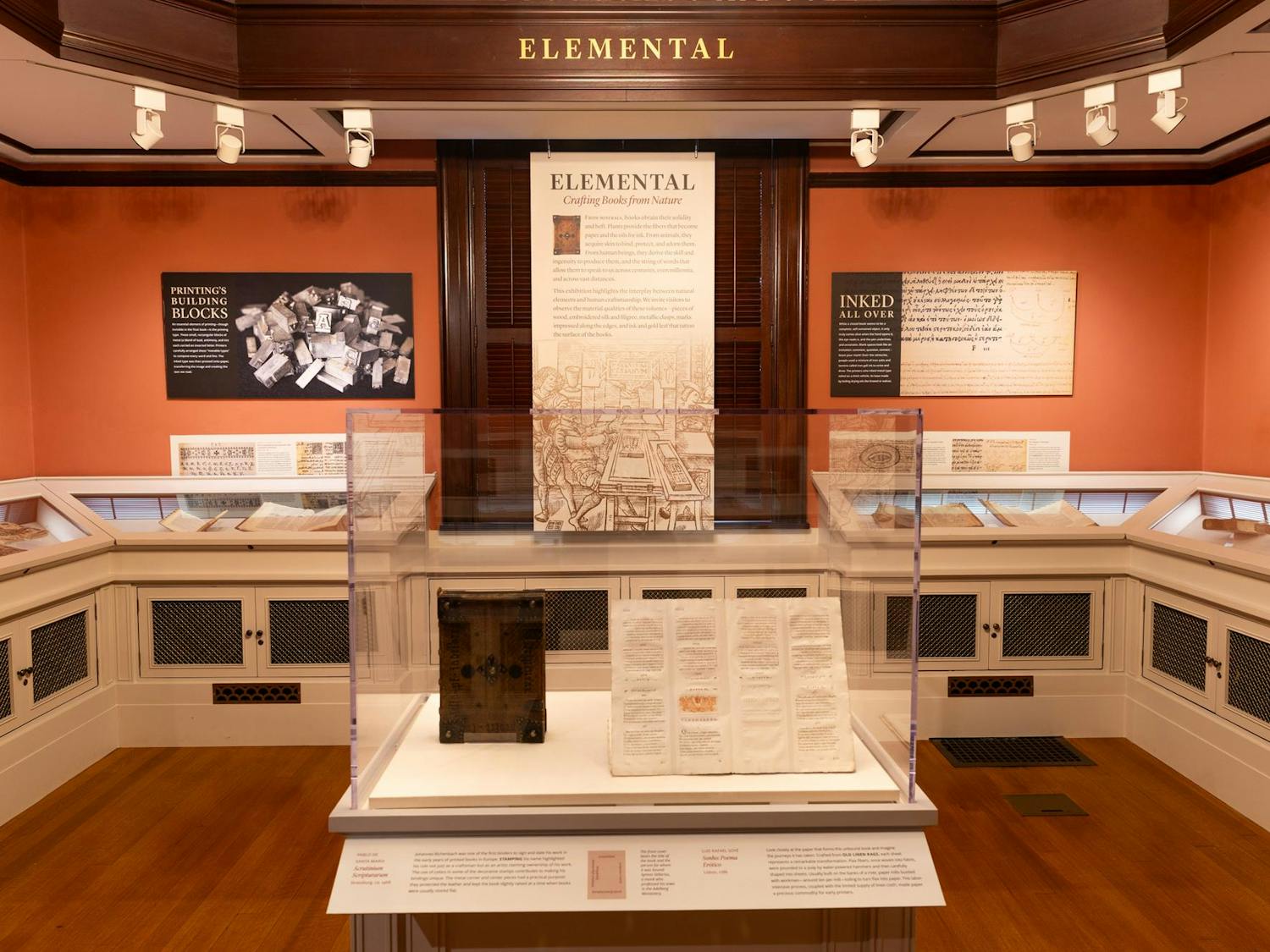 Display of old books in glass with exhibit titled "Elemental."