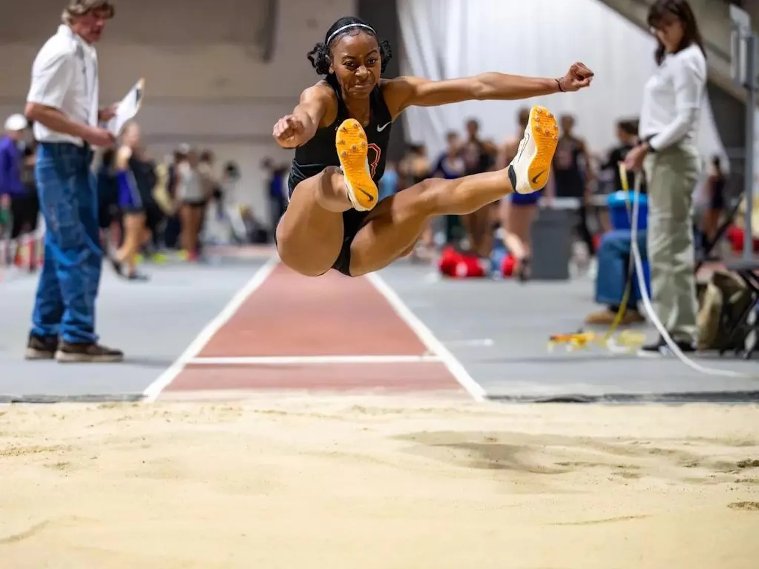 Jada Joseph is mid-jump over the sand, floating a few feet off the ground.