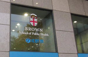 Photo of Brown School of Public Health logo on the window of a concrete building.
