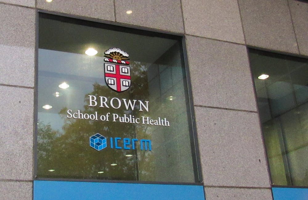Photo of Brown School of Public Health logo on the window of a concrete building.