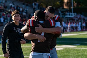 A photo of quarterback James Murphy emotionally hugging a teammate.
