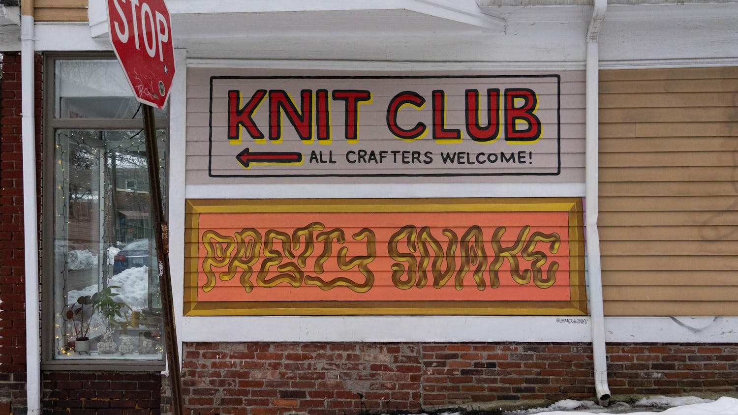 Wall text saying “Knit Club (left arrow) All Crafters Welcome!” and “Pretty Snake” with a stop sign on the front left.