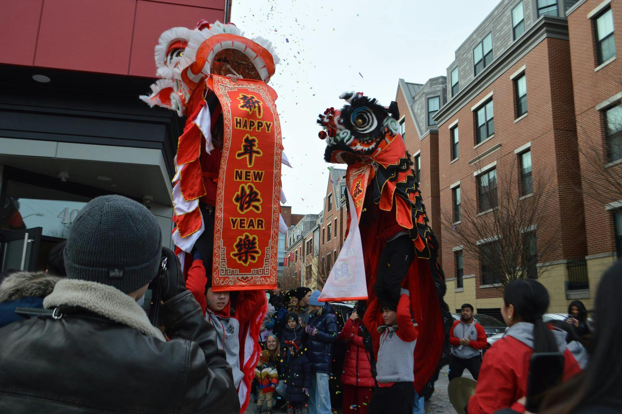 Lion Dancers holding a "Happy New Year" banner.