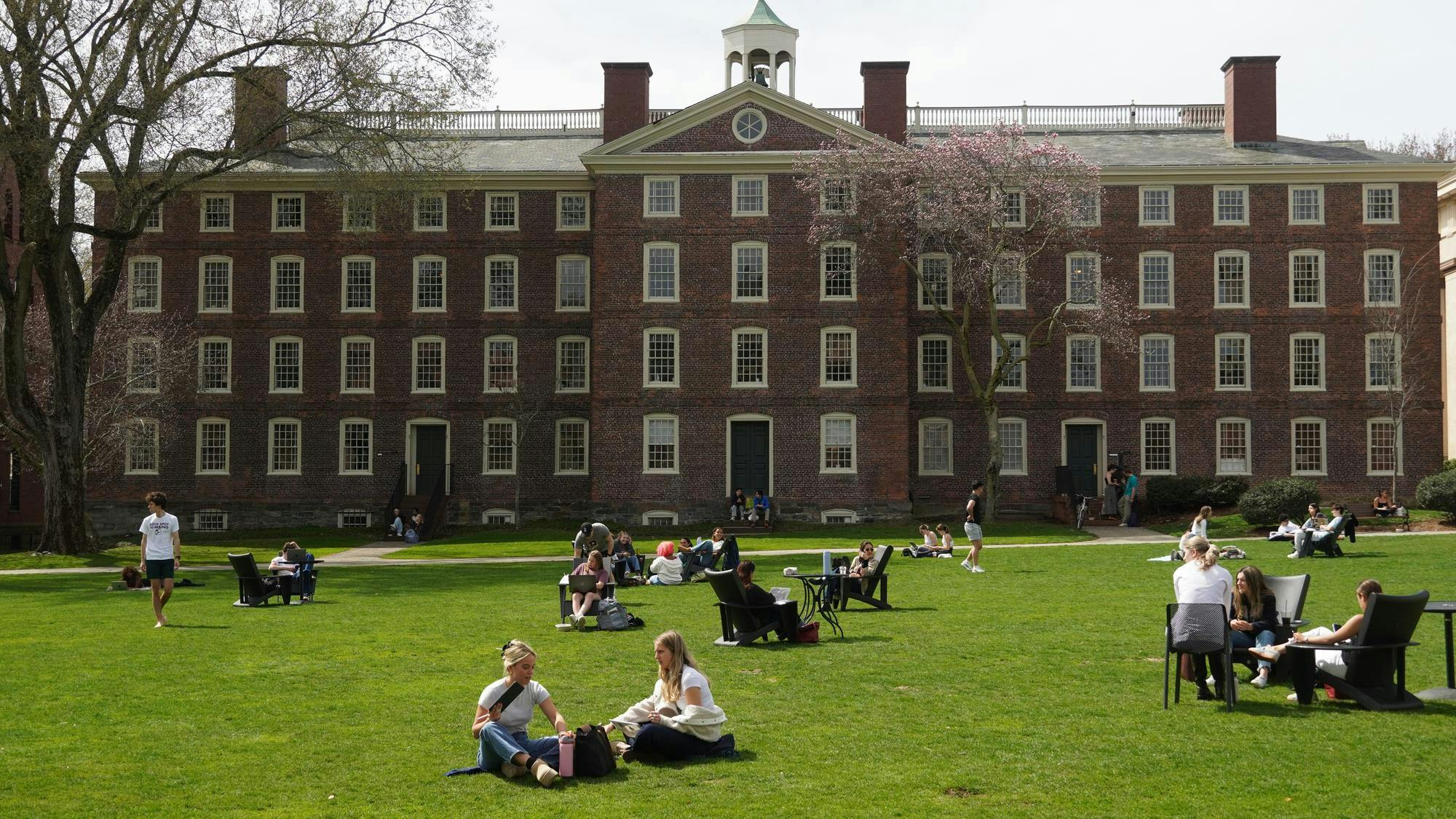 Students on the green in front of University Hall on a sunny day.