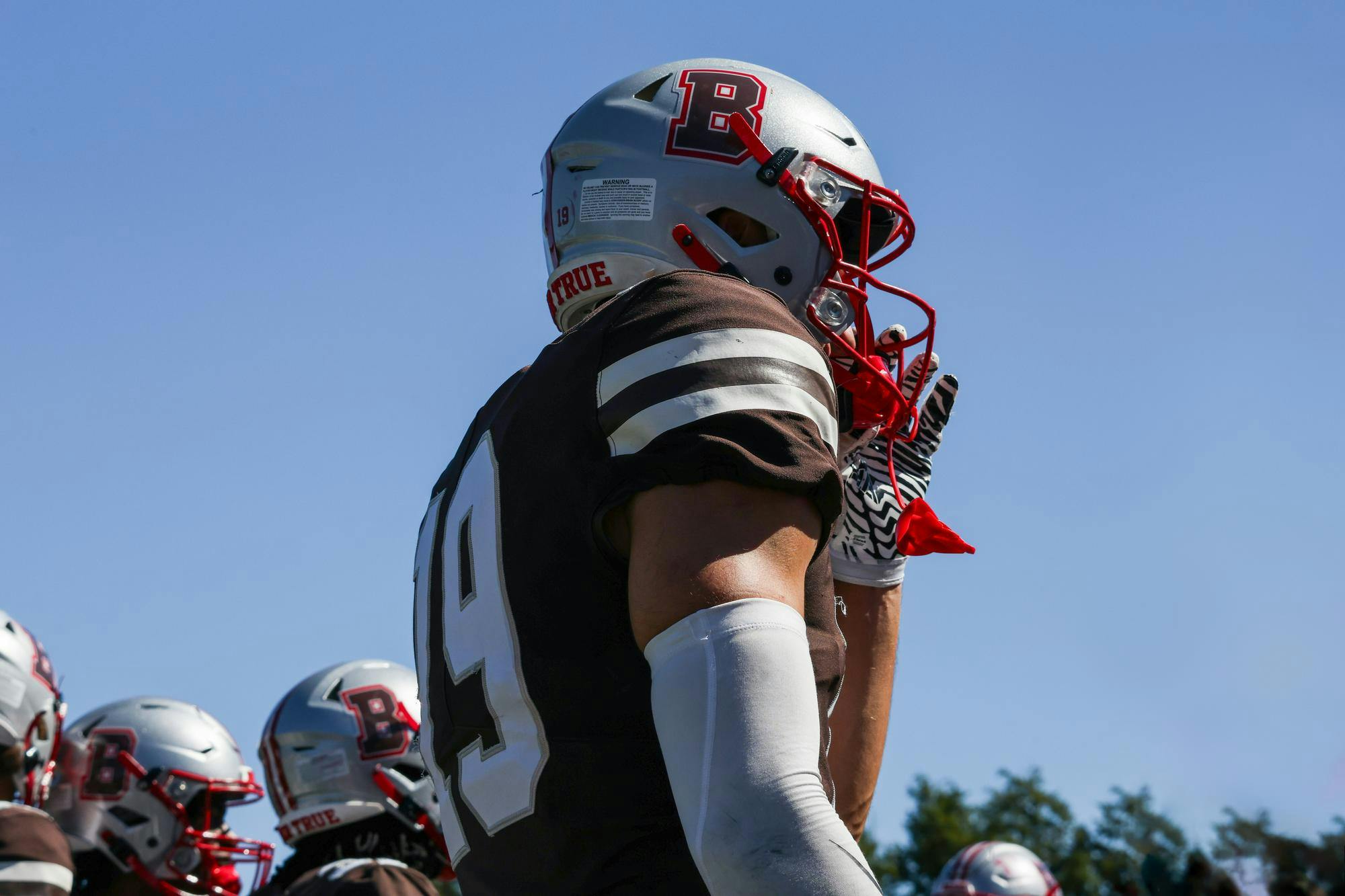 Photo of a Brown University football player in uniform viewed from below.