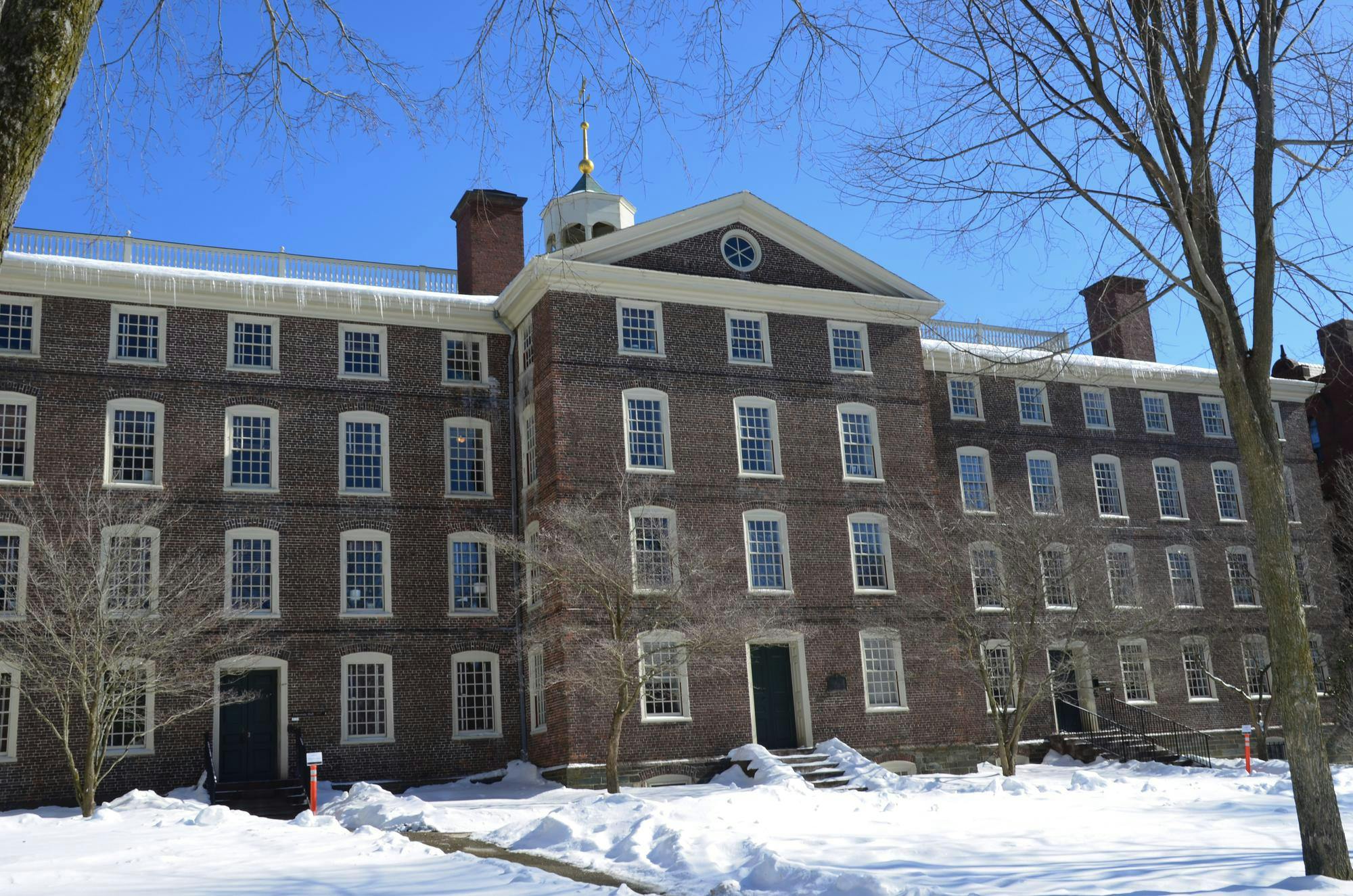 A photo of University Hall with snow on the Main Green in front of the building. 