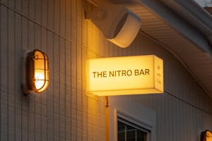 Photo of a square wall light displaying the words "The Nitro Bar"