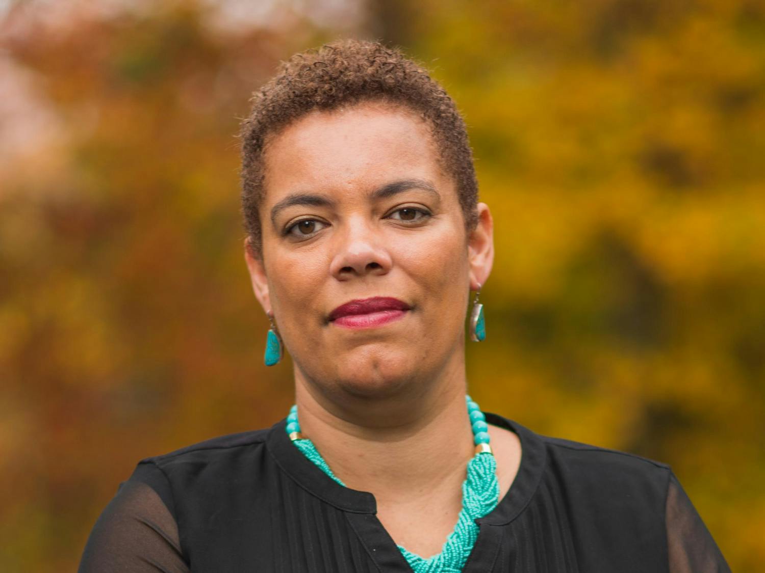 A photo of Avery Willis Hoffman in front of blurred out Fall foliage.