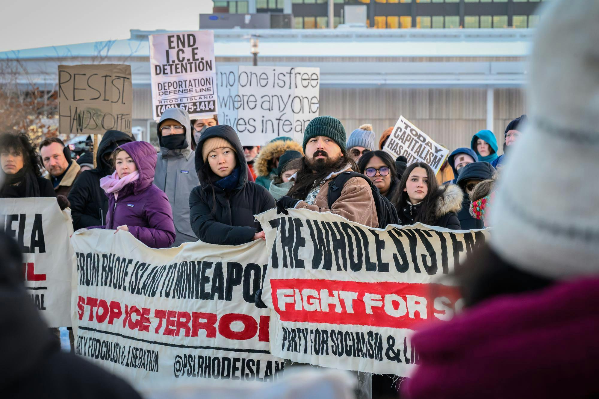 A group of protestors holding various anti-ICE signage. 