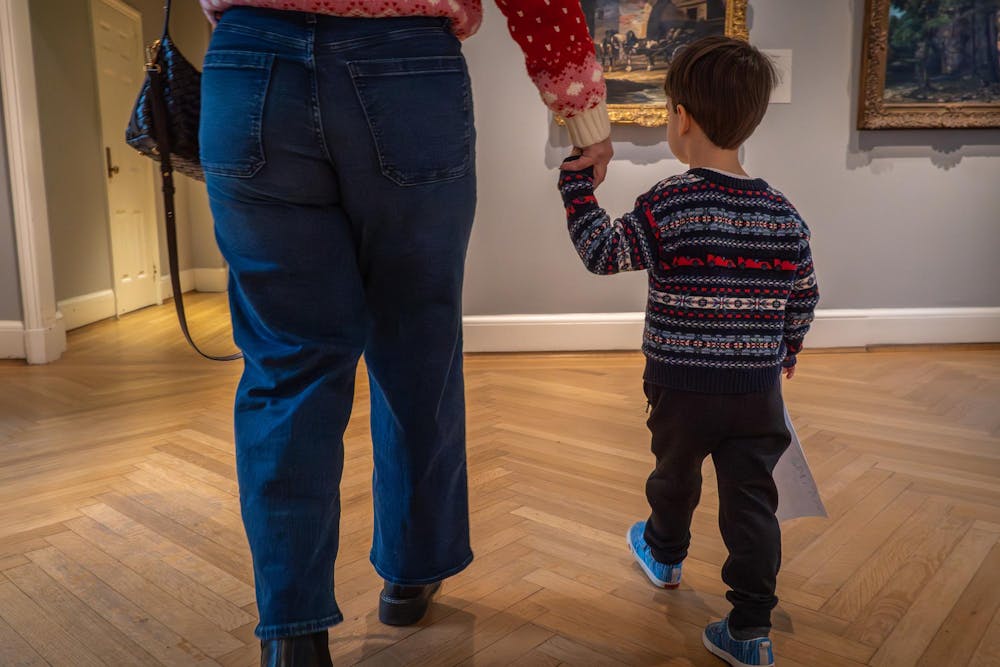 A child holds an adult's hand at the RISD Museum.