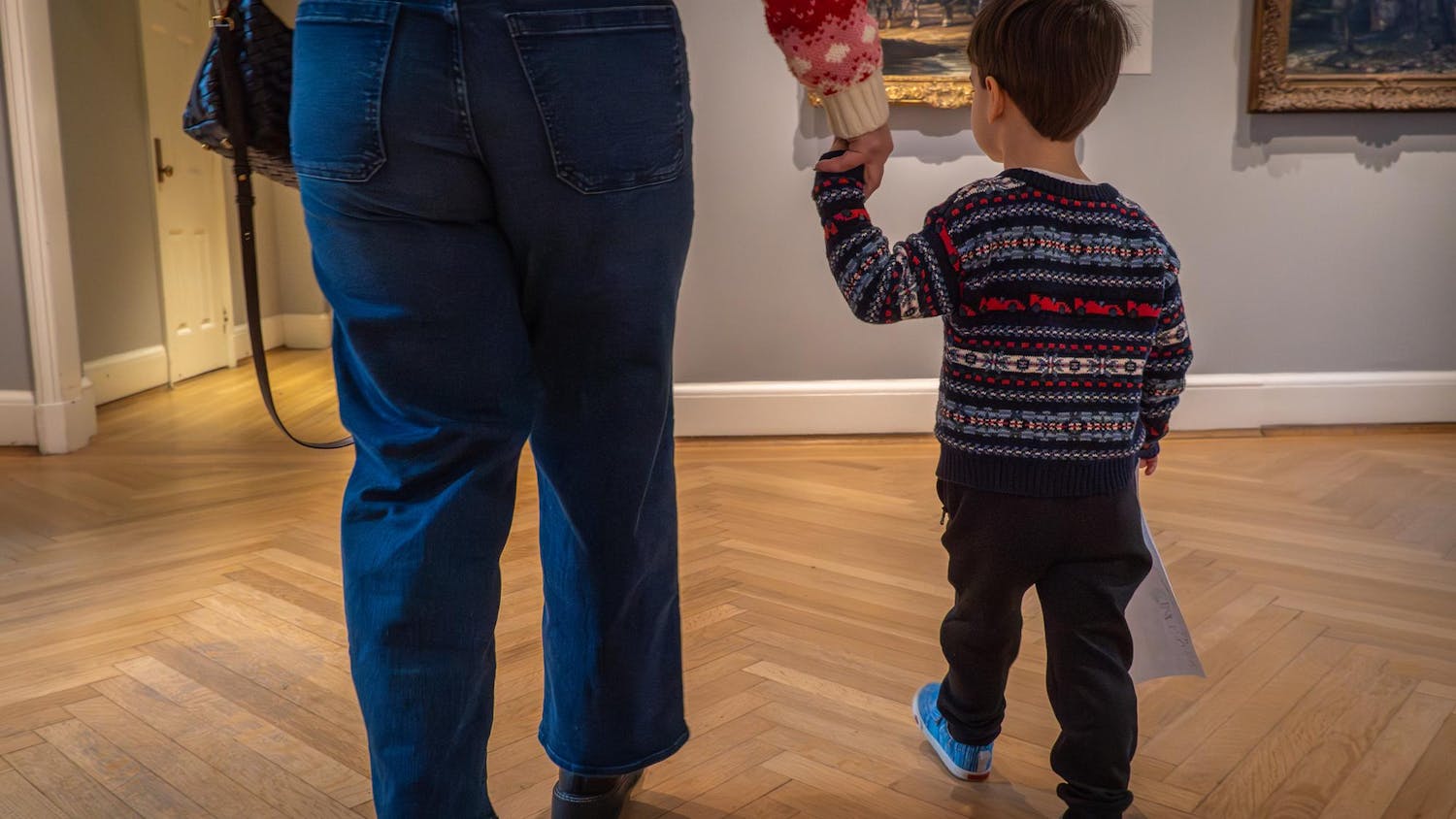 A child holds an adult's hand at the RISD Museum.