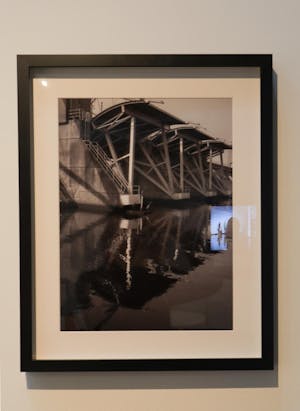 Photo of a framed photograph showing a hurricane barrier with a heron standing on it.