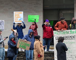A photo of group of protestors outside of Citizens Bank hold up various signs that read “BOYCOTT CITIZENS BANK,” “CITIZEN BANK FUNDS ICE PRISONS,” “CITIZENS BANK IS COMPLICIT WITH ICE,” and “ABOLISH ICE.”