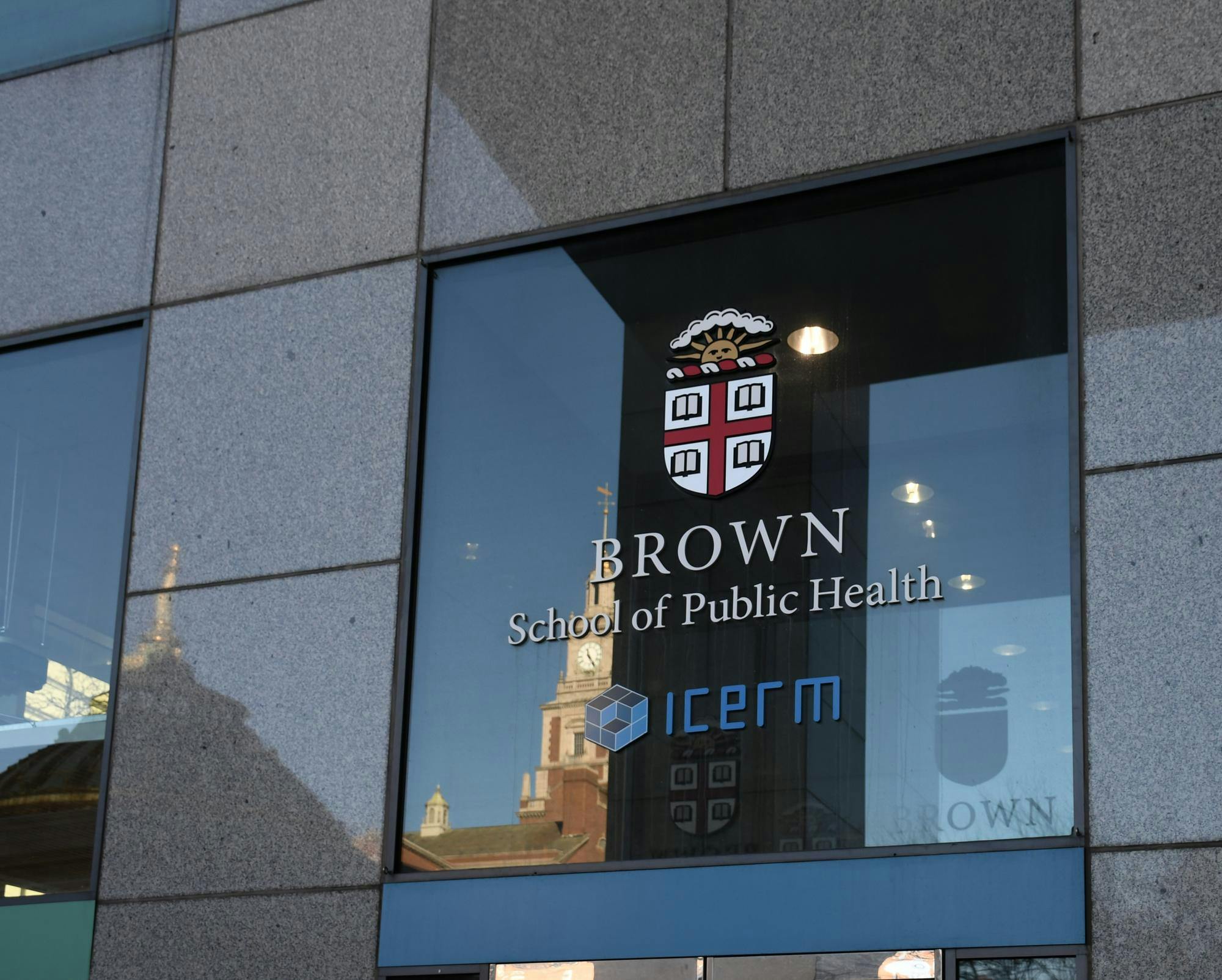 Photo of the outside of the School of Public Health featuring the Brown University insignia.
