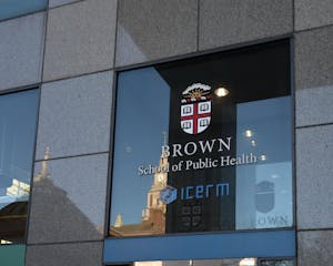 Photo of the outside of the School of Public Health featuring the Brown University insignia.
