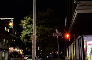 A photo of the intersection between Thayer street and Angell street at night.