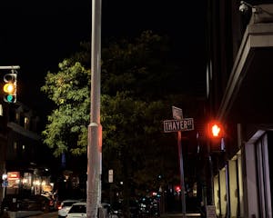 A photo of the intersection between Thayer street and Angell street at night.