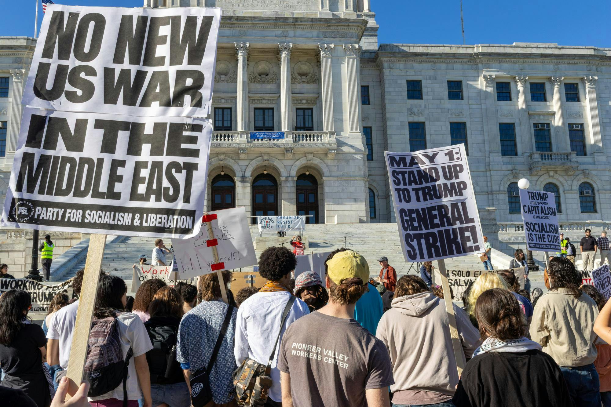 Photo of protestors holding signs opposing war in the Middle East in front of the Rhode Island State House.