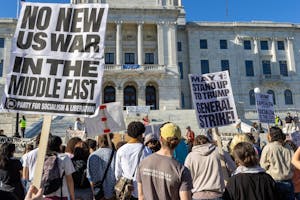 Photo of protestors holding signs opposing war in the Middle East in front of the Rhode Island State House.