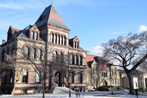 Sayles Hall, on Brown's campus, stands in the sunlight against the blue sky. 