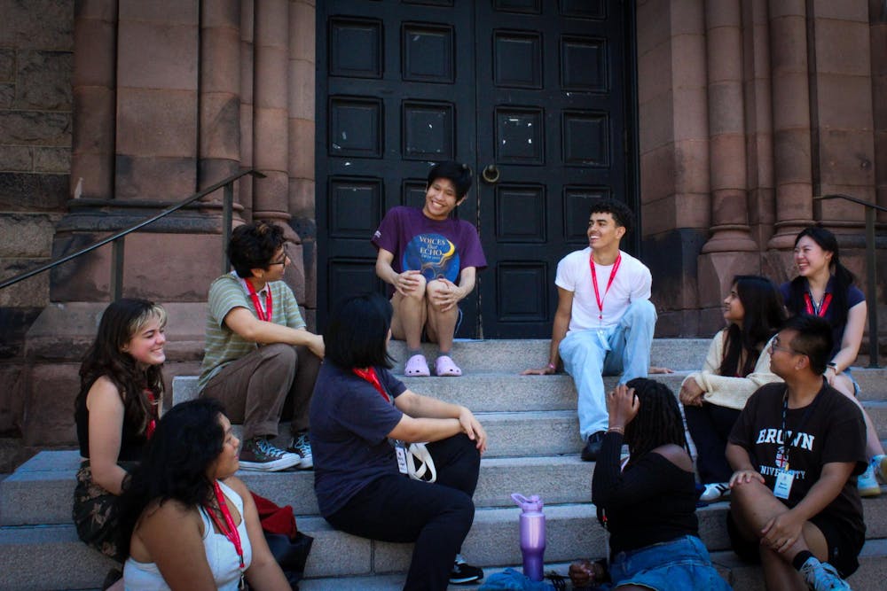 Photo of students sitting on stairs having a conversation.