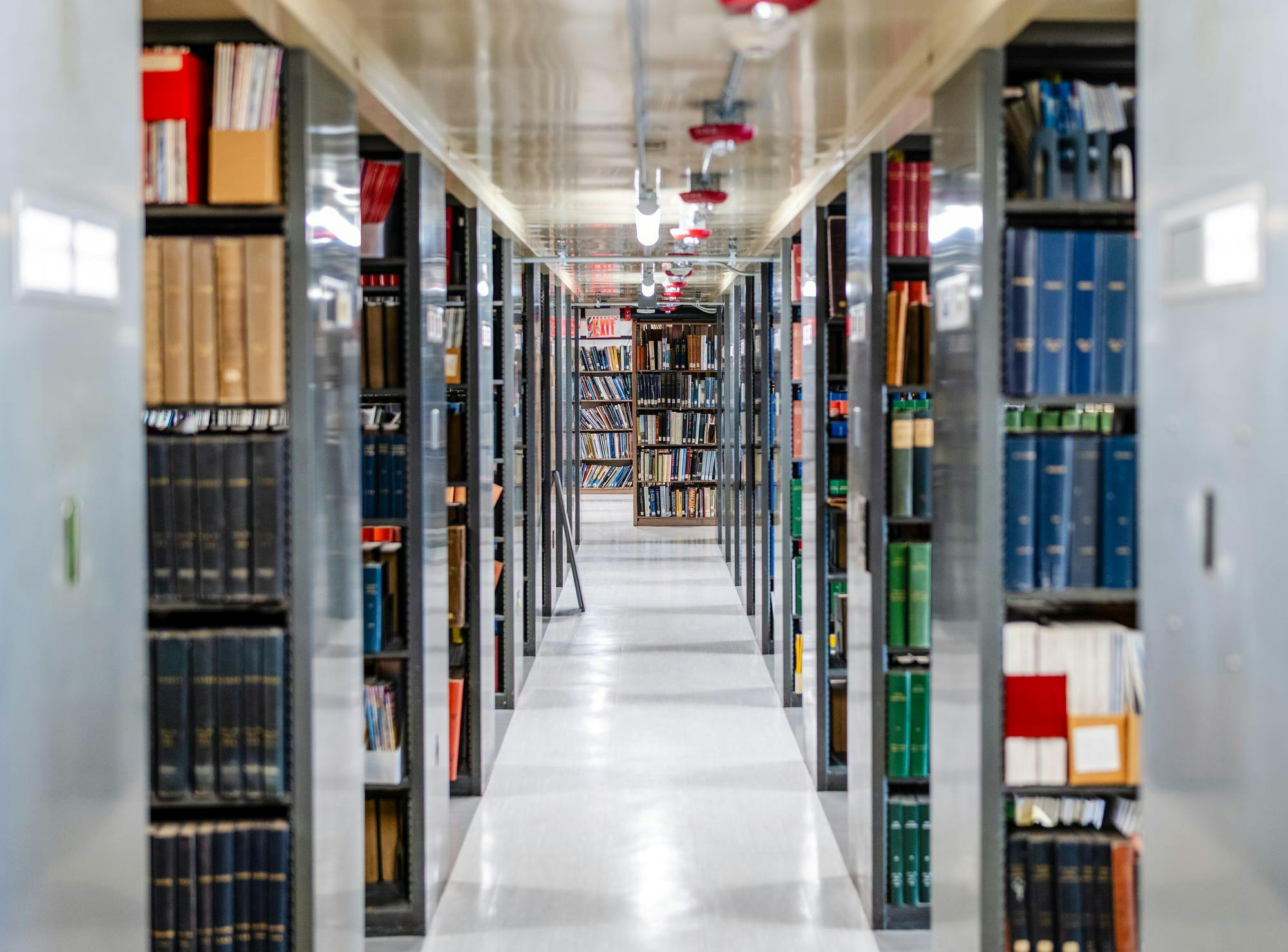 A long hallway in between shelves of books.