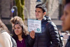 A man holds a sign saying "I'm voting YES for TALO because... every worker DESERVES a UNION."