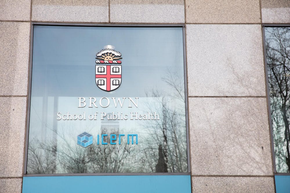 A close-up photograph of a window with the text “Brown School of Public Health” printed on the glass.