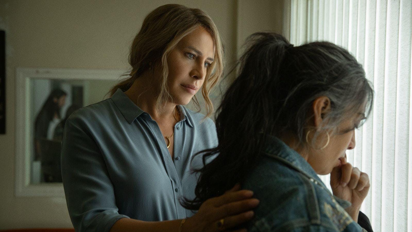 Image from the film "Emilia Pérez" of two characters with the one on the left comforting the one on the right.