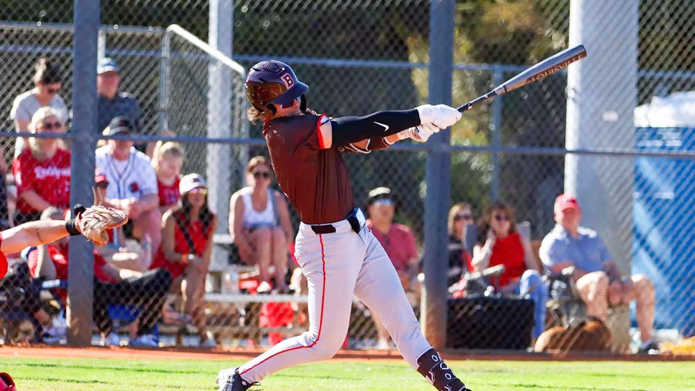 A photo of a Brown baseball player swinging a bat.