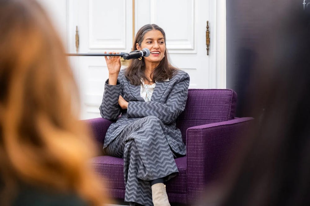 Photo of Jhumpa Lahiri sitting with a microphone in front of her face during Tuesday's talk.