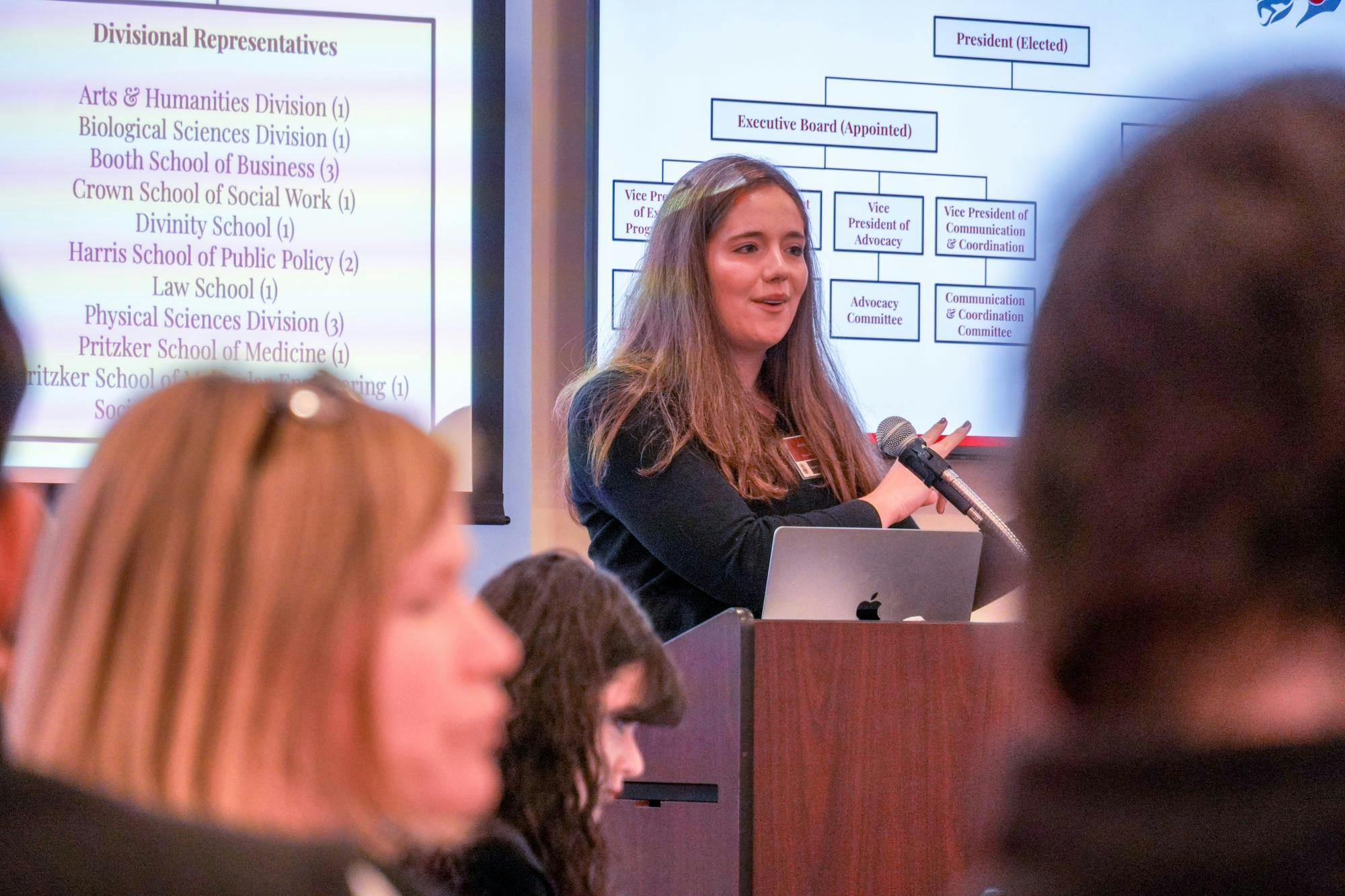 A Woman speaking at a podium. 