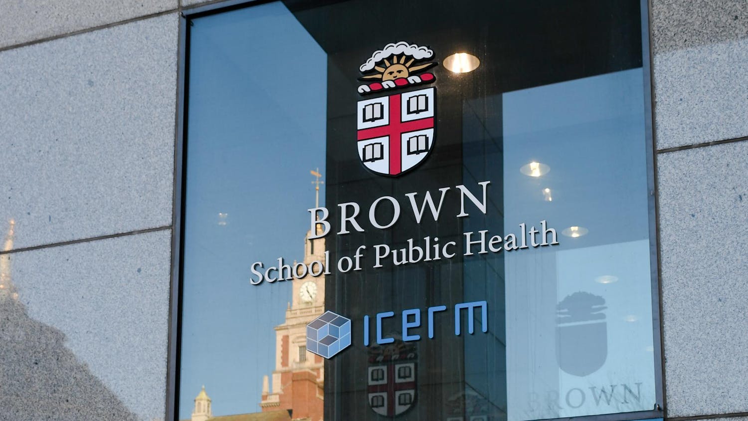 A black window with grey concrete around it, the window features a Brown crest and the words "Brown School of Public Health" and "ICERM."