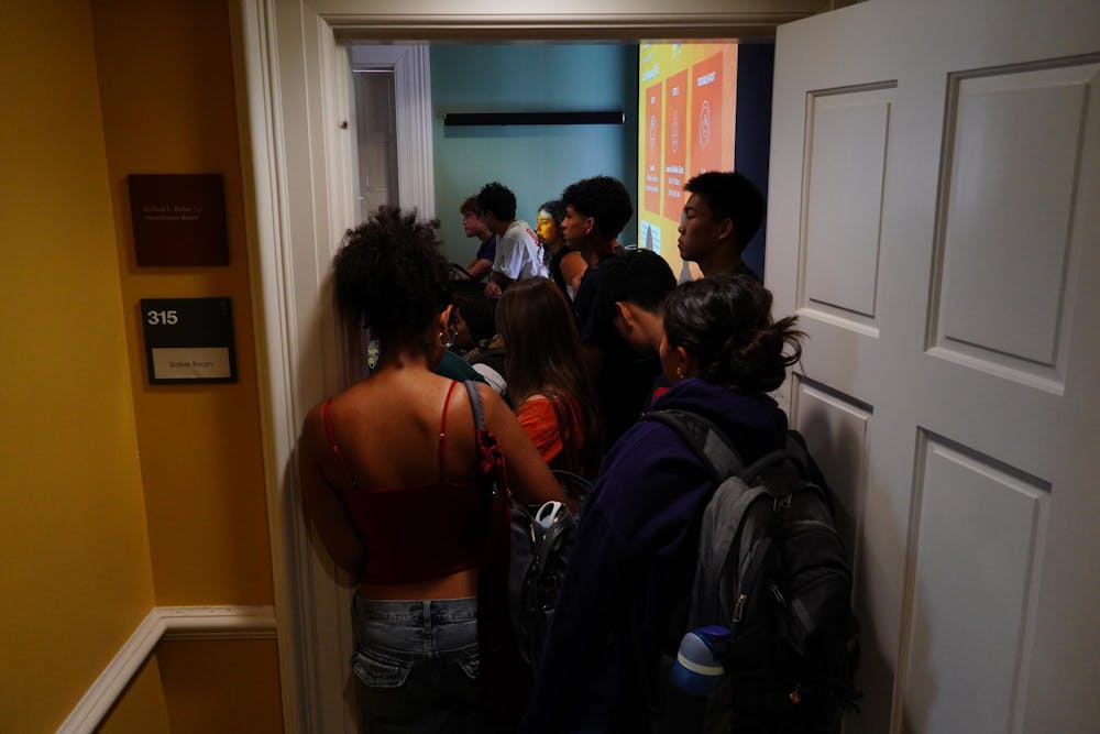 Photo of a group of students crowding a doorway leading to a packed classroom.