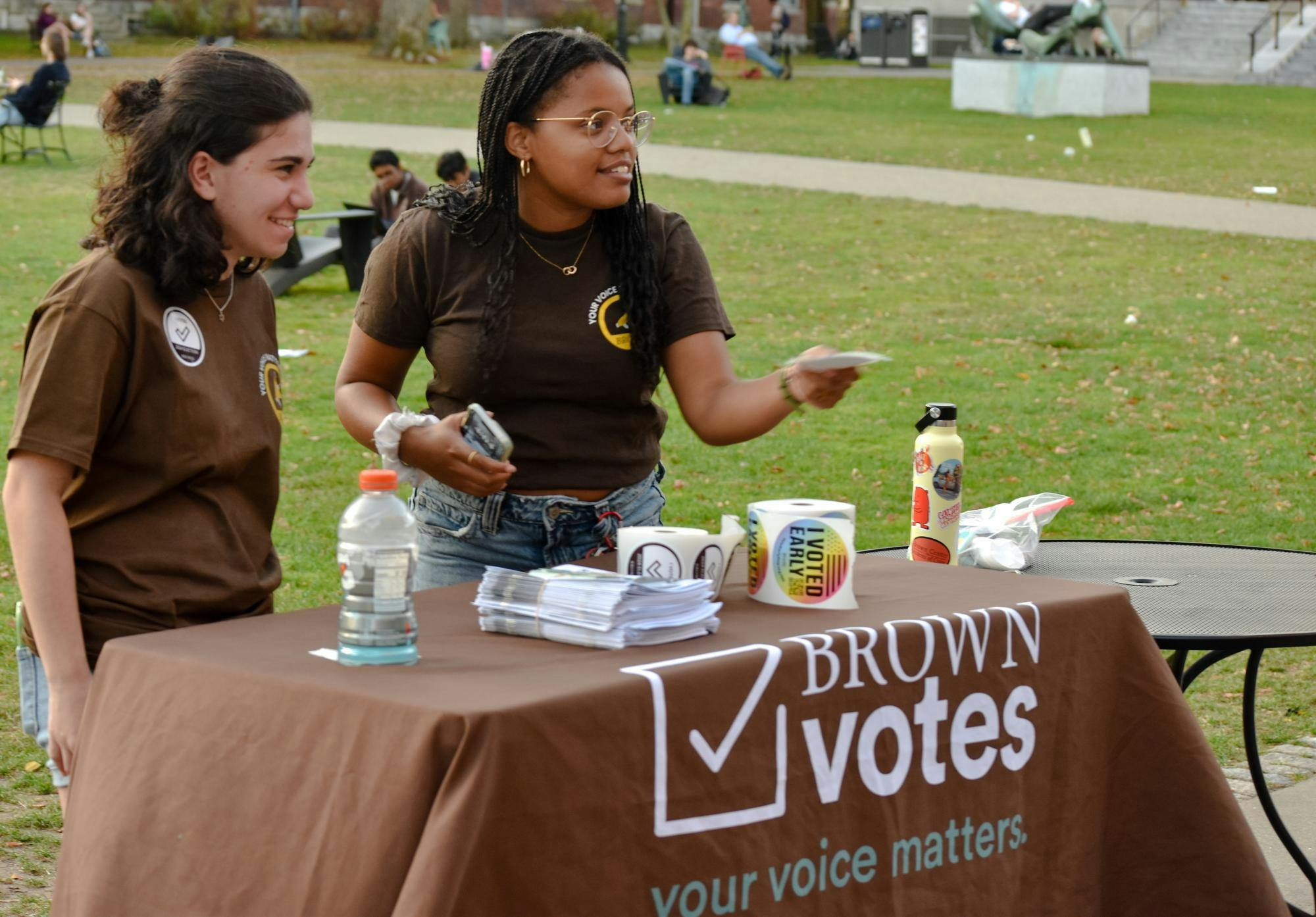 The Brown Vote booth on the main green, with two students behind the table.