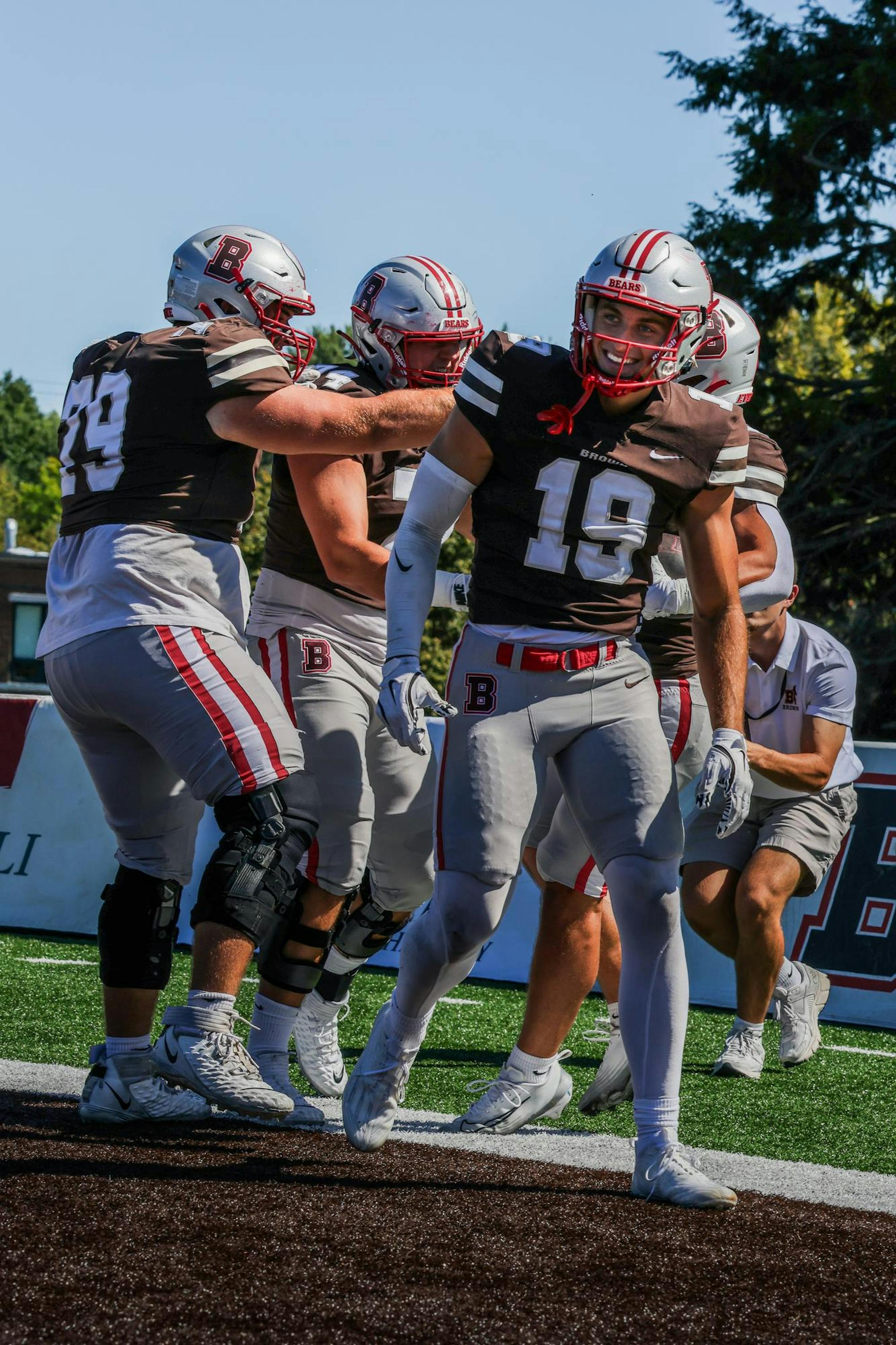 Photo of Brown University football players celebrating in the end zone.