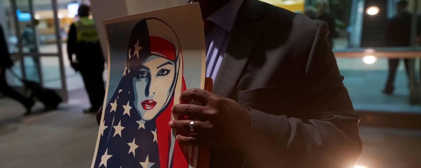 Above, a protester holds a “We the People” sign during a rally against the travel ban at San Diego International Airport on March 6, 2017. | SANDY HUFFAKER/AFP via Getty Images