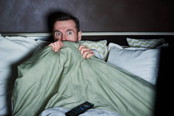 Scared person watching horror movies at night | Source: iStock