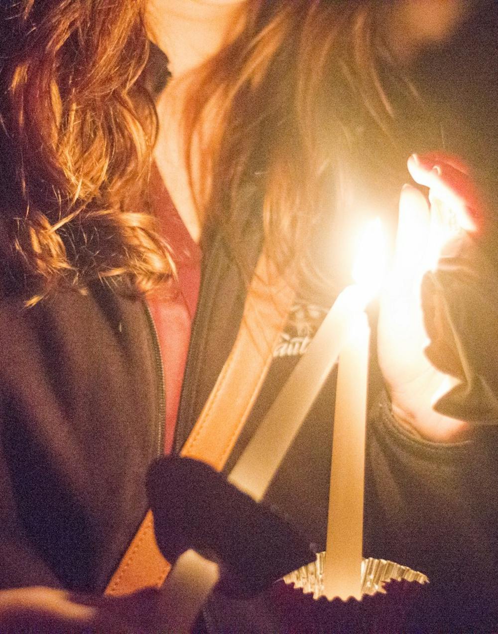Students light candles at Take Back the Night on Oct. 14 at the Quad. Take Back the Night is a march to spread domestic violence. DN PHOTO ALAINA JAYE HALSEY