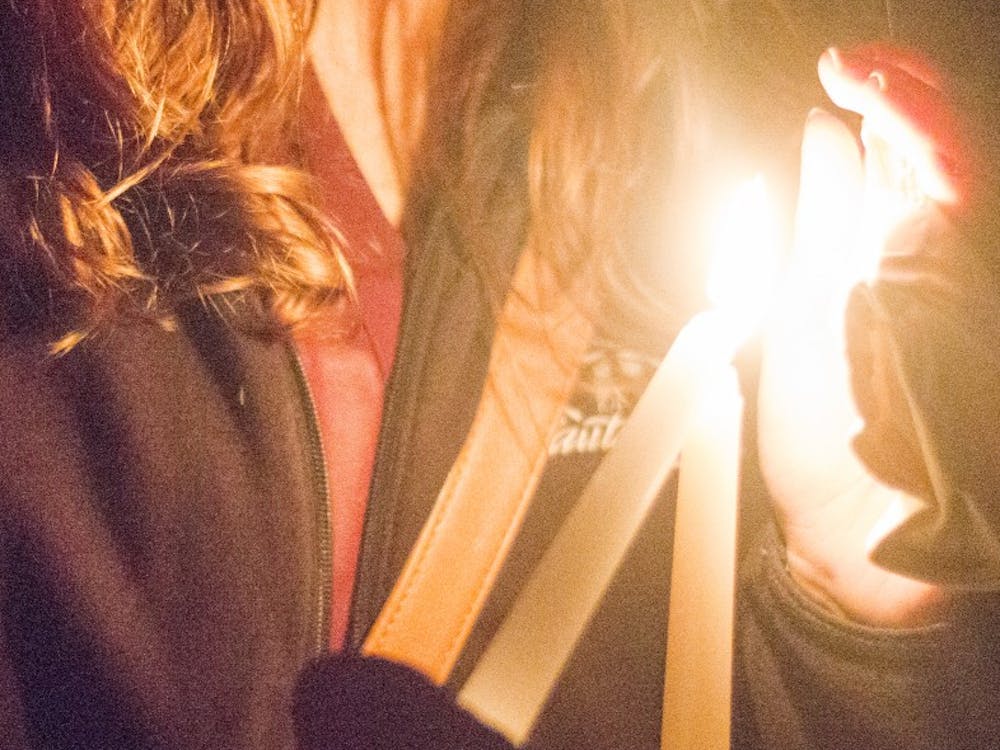Students light candles at Take Back the Night on Oct. 14 at the Quad. Take Back the Night is a march to spread domestic violence. DN PHOTO ALAINA JAYE HALSEY