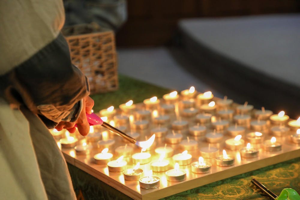 <p>An attendee lights a candle during a community vigil June 30 at Avondale Methodist Church in Muncie, Indiana. The vigil was held to bring awareness to the recent deportation of a Muncie community member. Trinity Rea, DN</p>