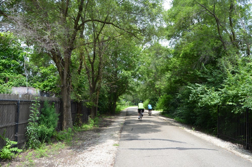 People ride their bike on a Cardinal Greenway trail toward Ball State's campus. PHOTO BY MIKAELA MARANHAS