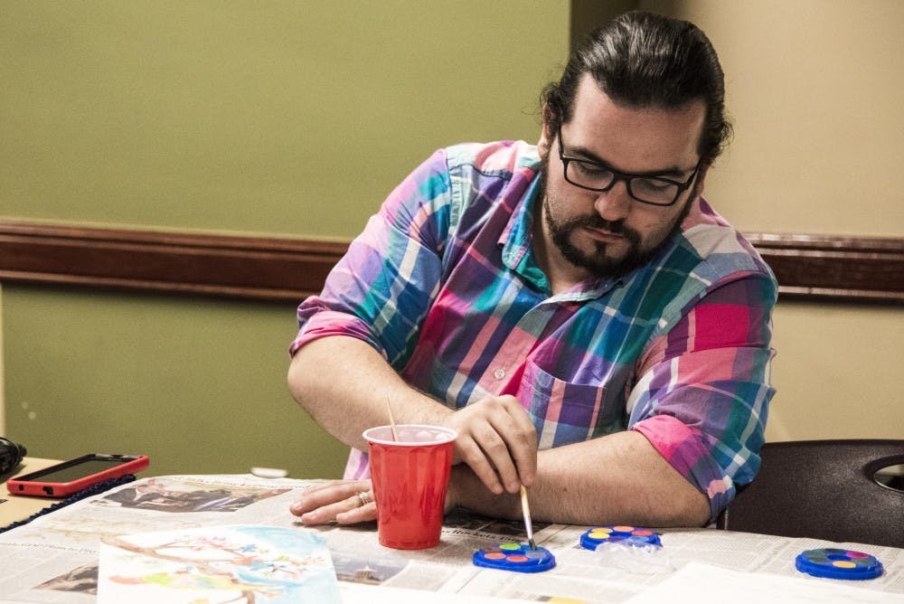 Hunter Sully, a graduate student, paints a water color of a parrot. The Asian American Student Association held the water painting event as part of their month of events. DN PHOTO RACHEL BRAMMER