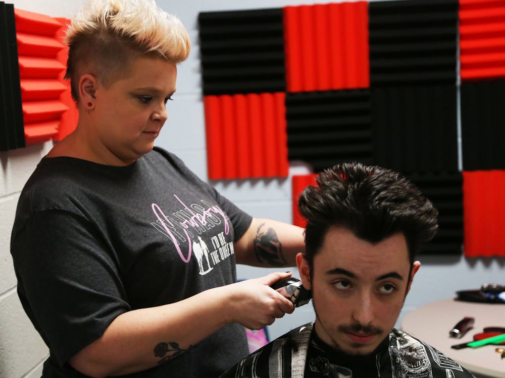 Hair stylist Kaitlynne Buis (left) cuts the hair of Delaware County Jail inmate Chance Herbert (right) Sept. 27 at the Delaware County jail. Mya Cataline, DN