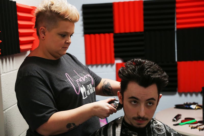 Hair stylist Kaitlynne Buis (left) cuts the hair of Delaware County Jail inmate Chance Herbert (right) Sept. 27 at the Delaware County jail. Mya Cataline, DN